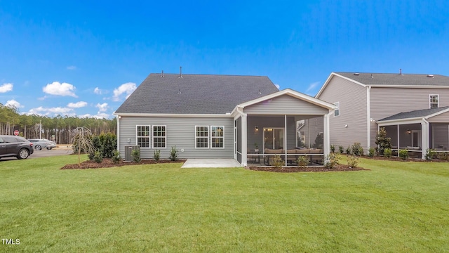 rear view of house featuring a patio, a sunroom, and a lawn