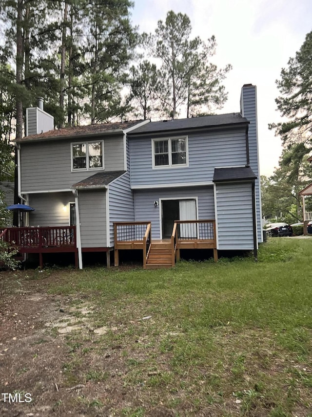 back of house with a wooden deck and a yard