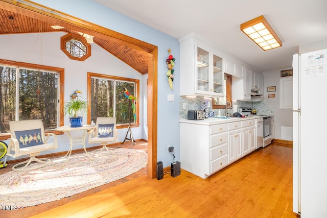 kitchen with white refrigerator, white cabinetry, stainless steel electric range, and backsplash