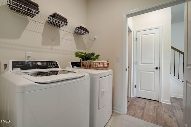 laundry area featuring washer and dryer and light hardwood / wood-style flooring