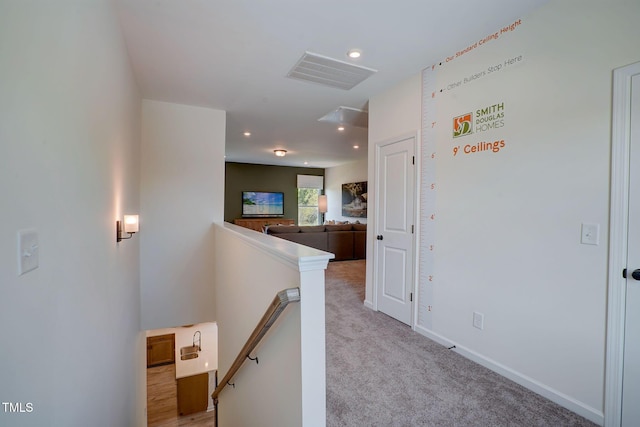 hallway with light colored carpet