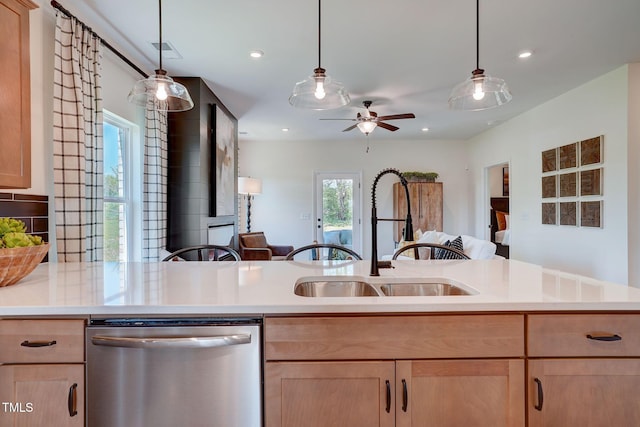 kitchen featuring light brown cabinetry, sink, hanging light fixtures, and dishwasher