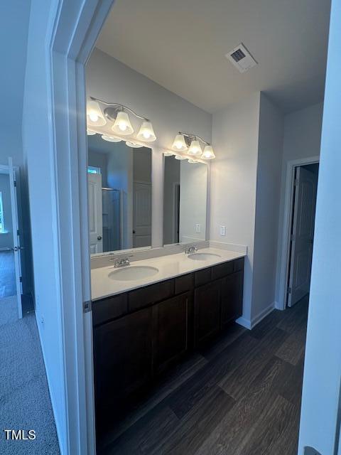 142 Vega Loop, Sanford, NC 27330 - full bath with double vanity, wood finished floors, a shower with shower door, and baseboards