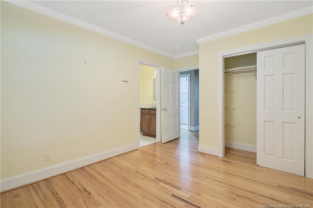 unfurnished bedroom featuring crown molding, light hardwood / wood-style floors, and a closet