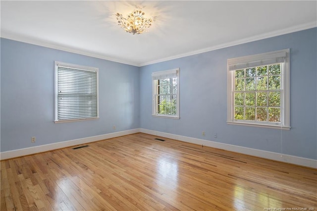 empty room featuring crown molding and light hardwood / wood-style flooring