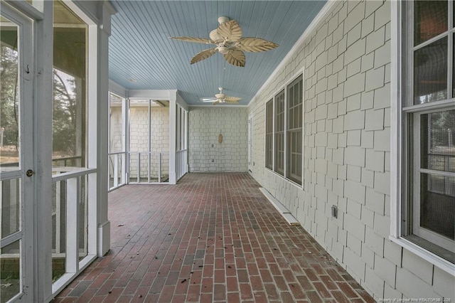 unfurnished sunroom with wood ceiling and ceiling fan