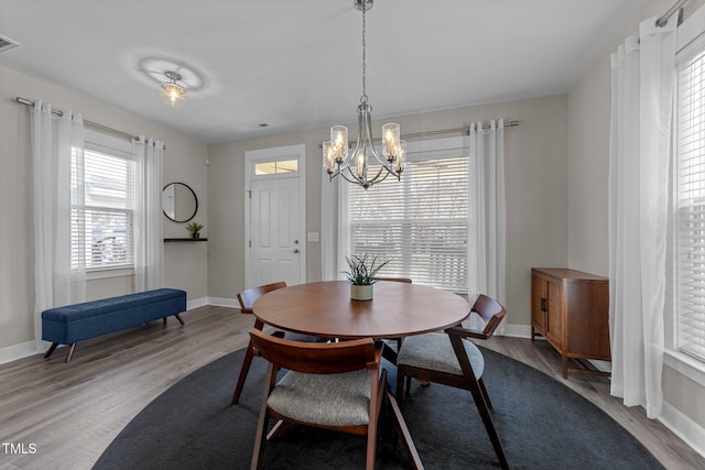 dining space with a notable chandelier and light hardwood / wood-style flooring