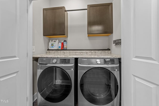 laundry area featuring separate washer and dryer and cabinets