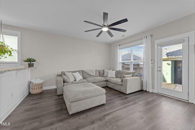 living room with dark hardwood / wood-style floors and ceiling fan