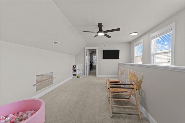 sitting room with vaulted ceiling, light carpet, and ceiling fan