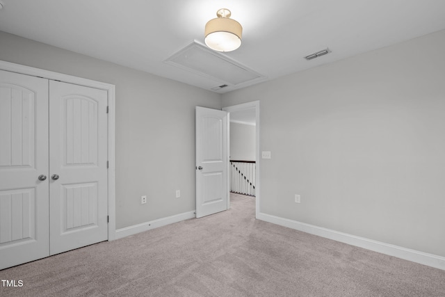 unfurnished bedroom featuring a closet and light carpet