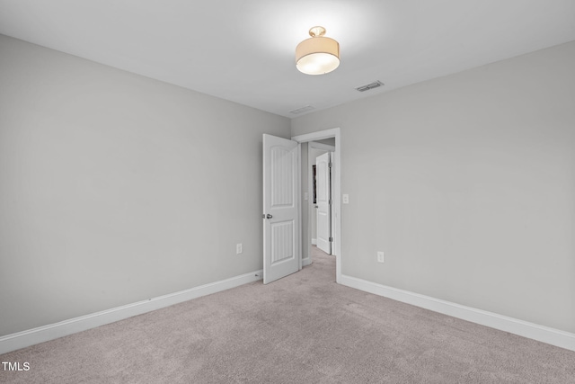 spare room featuring light colored carpet