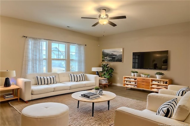 living room featuring wood-type flooring and ceiling fan