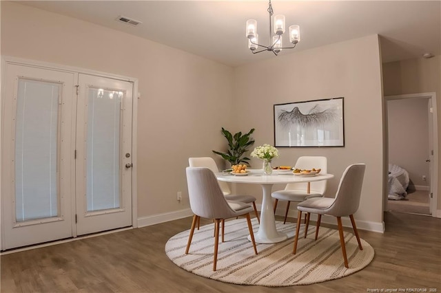 dining room featuring dark hardwood / wood-style floors and a notable chandelier