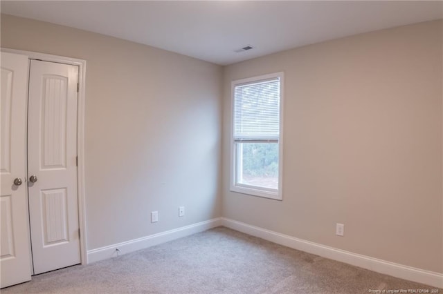 unfurnished room featuring light colored carpet