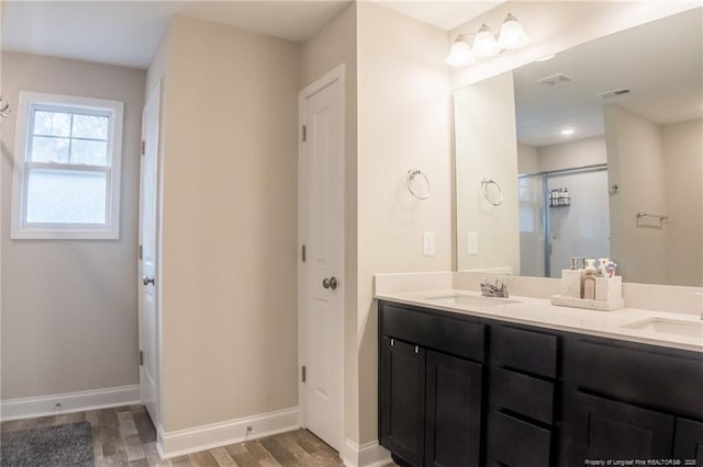 bathroom featuring hardwood / wood-style flooring, vanity, and walk in shower