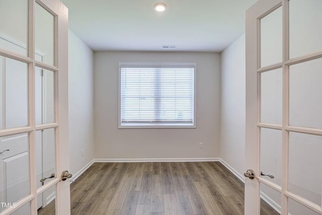 unfurnished room with light hardwood / wood-style floors and french doors