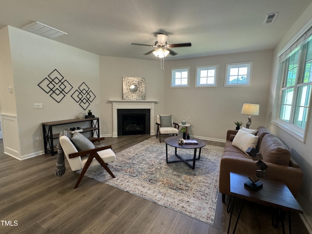 living room with dark wood-type flooring and ceiling fan