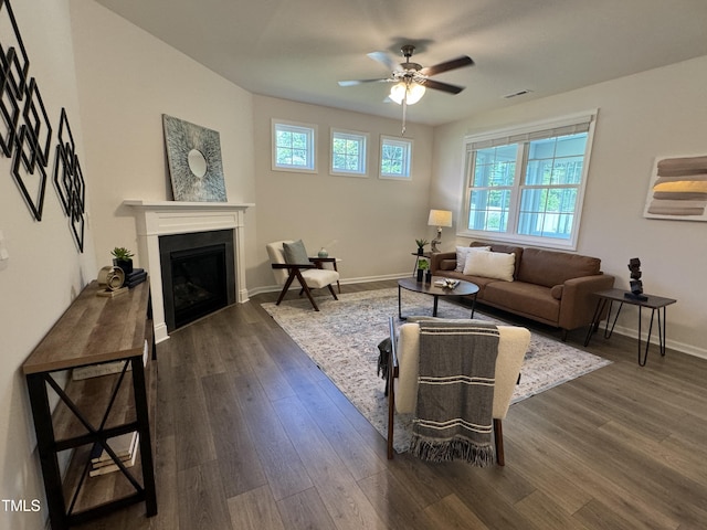 living room featuring dark wood-type flooring and ceiling fan