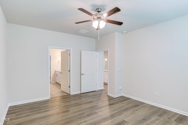 unfurnished bedroom with ensuite bath, ceiling fan, and light wood-type flooring