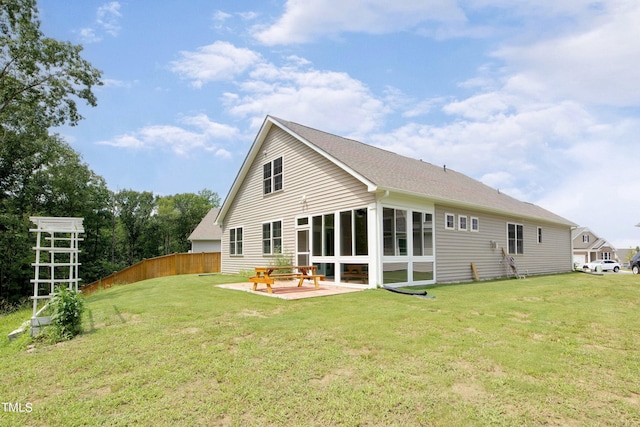 rear view of property with a sunroom, a lawn, and a patio area