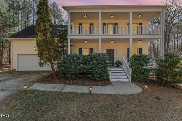 view of front of property with a garage, a balcony, and a porch