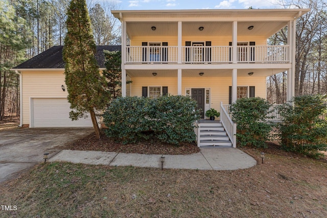 view of front facade featuring a balcony, a garage, and a porch