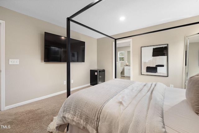 bedroom featuring ensuite bath and carpet flooring