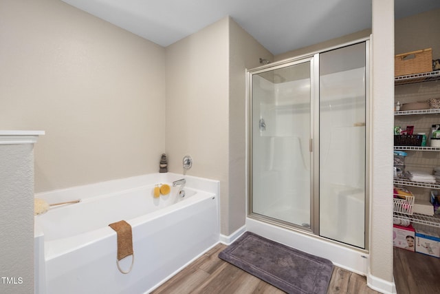 bathroom featuring shower with separate bathtub and hardwood / wood-style floors