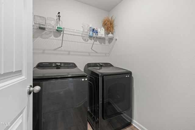 washroom with wood-type flooring and washer and clothes dryer