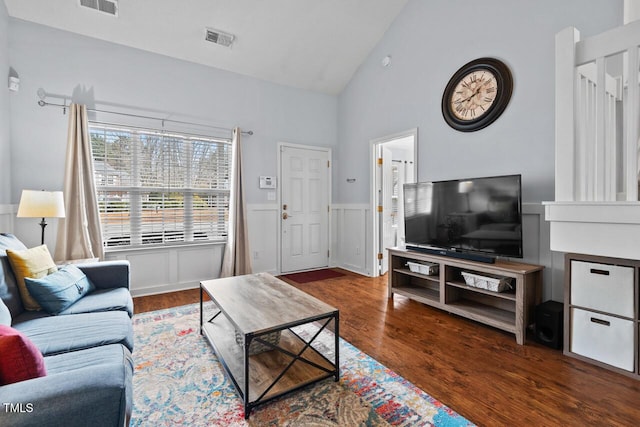 living room with high vaulted ceiling and dark hardwood / wood-style flooring