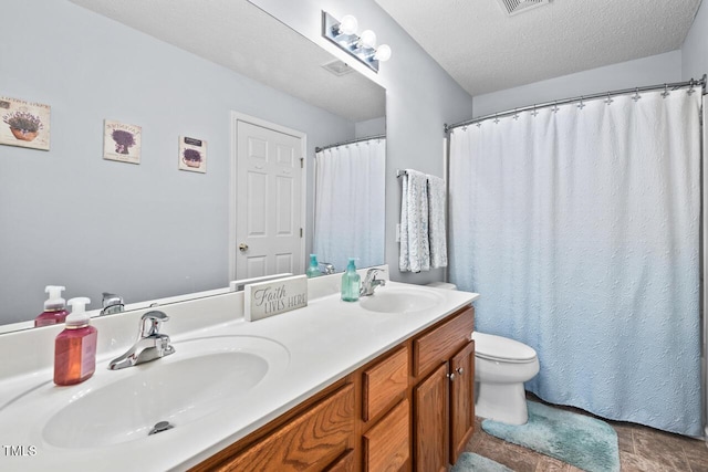 bathroom featuring vanity, a textured ceiling, and toilet