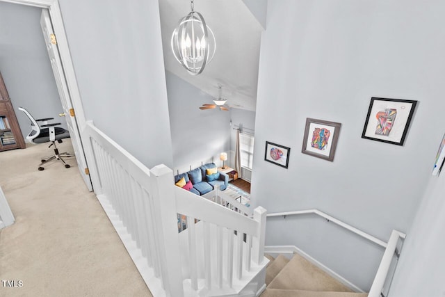 stairs with a notable chandelier and carpet floors