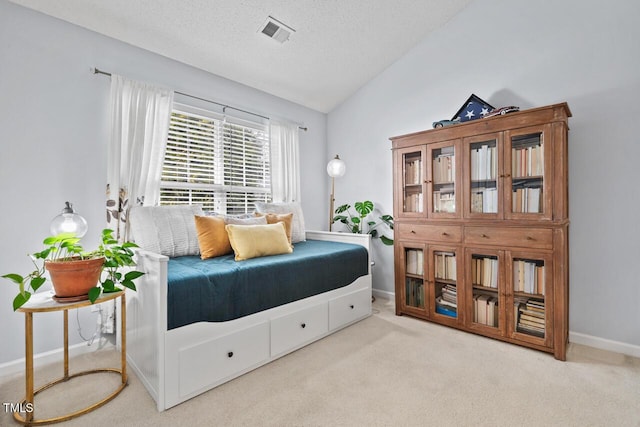 carpeted bedroom featuring vaulted ceiling and a textured ceiling