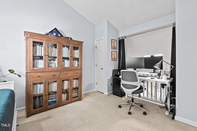 home office featuring lofted ceiling and light carpet