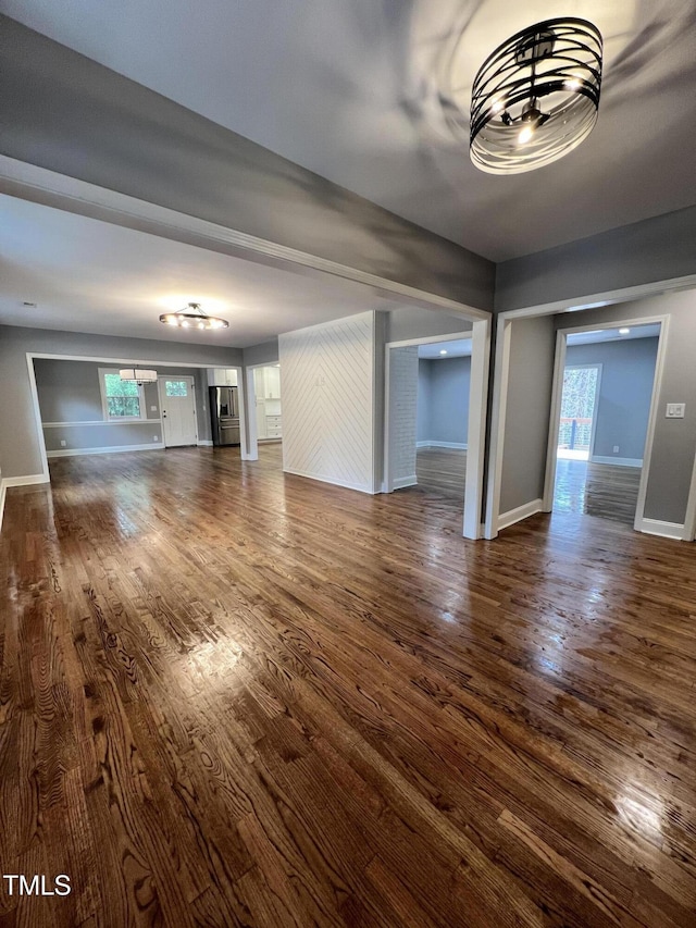 unfurnished living room with dark wood-type flooring and plenty of natural light