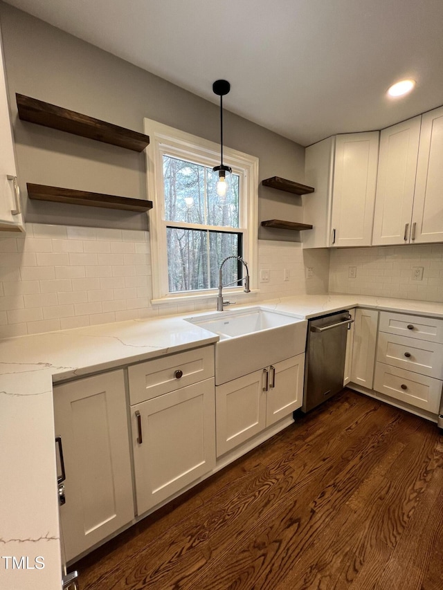 kitchen with dark hardwood / wood-style floors, white cabinetry, sink, stainless steel dishwasher, and light stone countertops