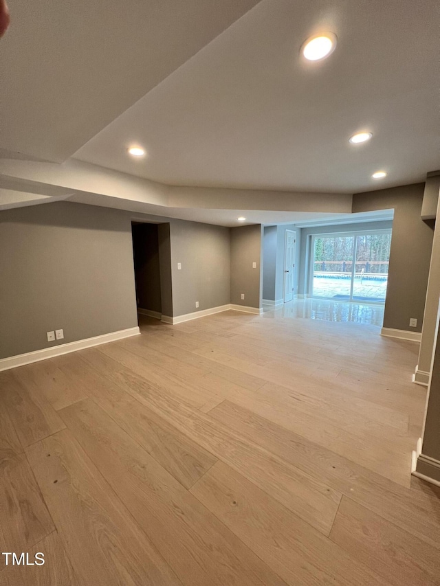 basement with light hardwood / wood-style flooring