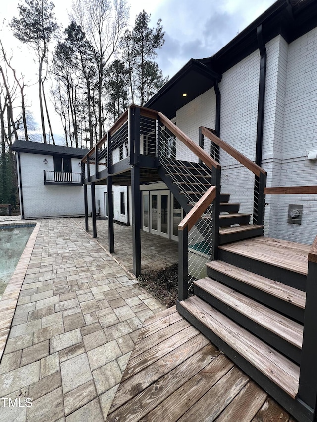 wooden terrace with a patio area and french doors