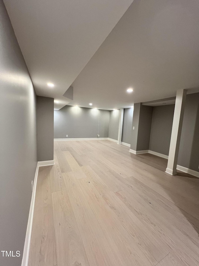 basement with light hardwood / wood-style floors