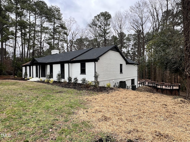 view of side of home featuring a yard and central air condition unit