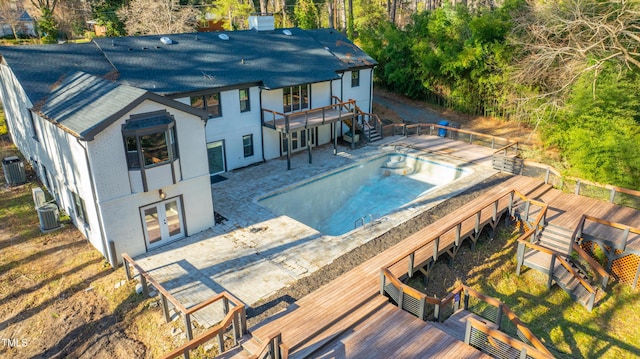 view of pool with a wooden deck, french doors, and cooling unit