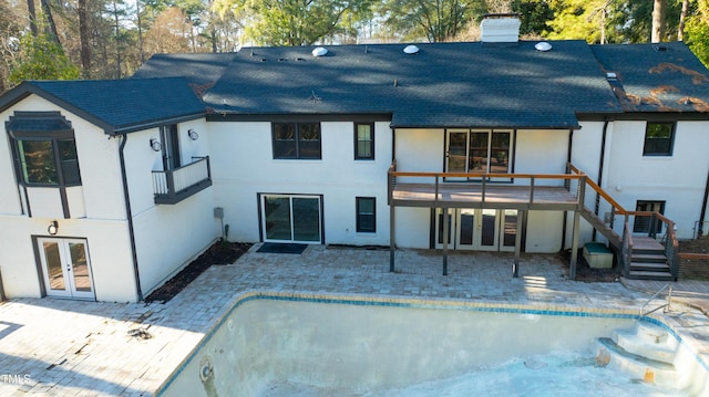 rear view of house featuring a patio, a wooden deck, and french doors