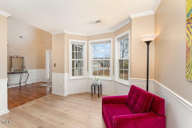 sitting room featuring crown molding and light hardwood / wood-style flooring