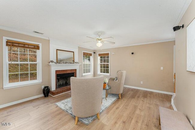 sitting room with ornamental molding, a brick fireplace, and light hardwood / wood-style floors