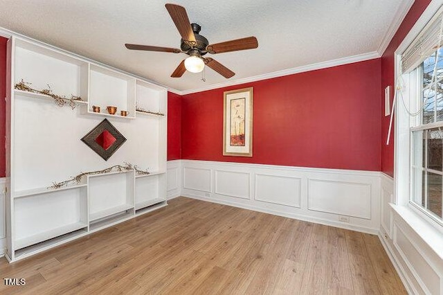 empty room with ornamental molding, light hardwood / wood-style floors, and ceiling fan