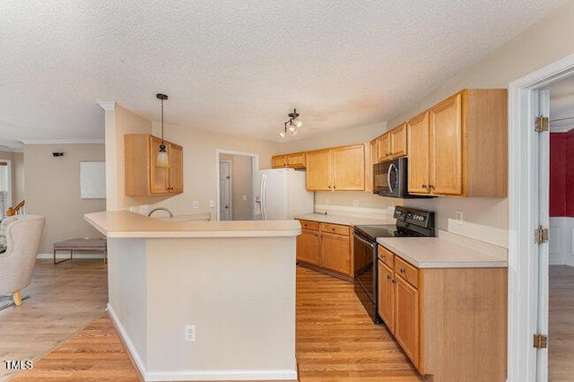 kitchen with decorative light fixtures, kitchen peninsula, light hardwood / wood-style floors, and black appliances