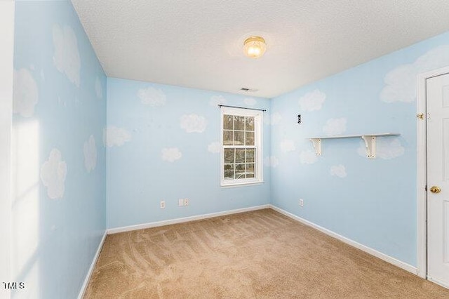 unfurnished room featuring light colored carpet and a textured ceiling