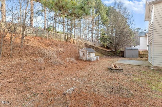 view of yard with a shed and a fire pit