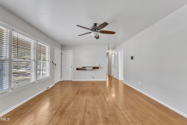 unfurnished living room with visible vents, wood finished floors, baseboards, and ceiling fan